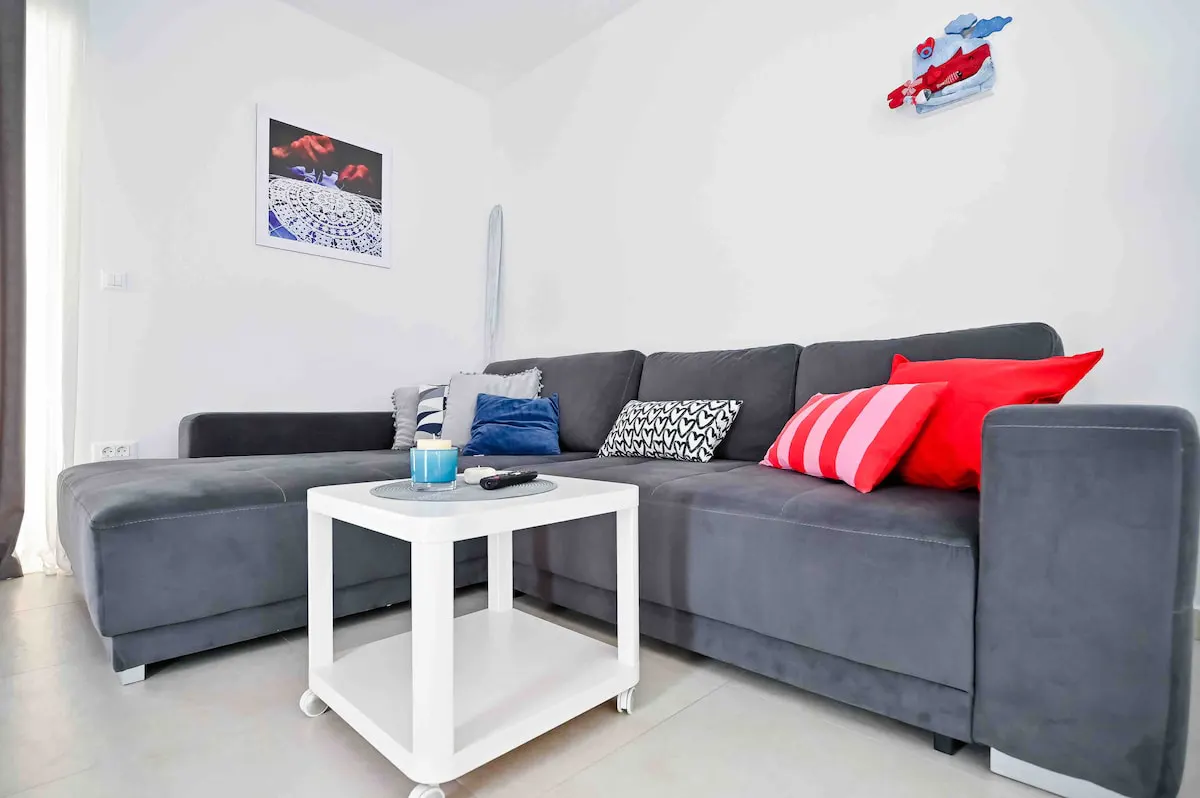 Gray sofa, cushions and coffee table at Apartment Festini in Pag