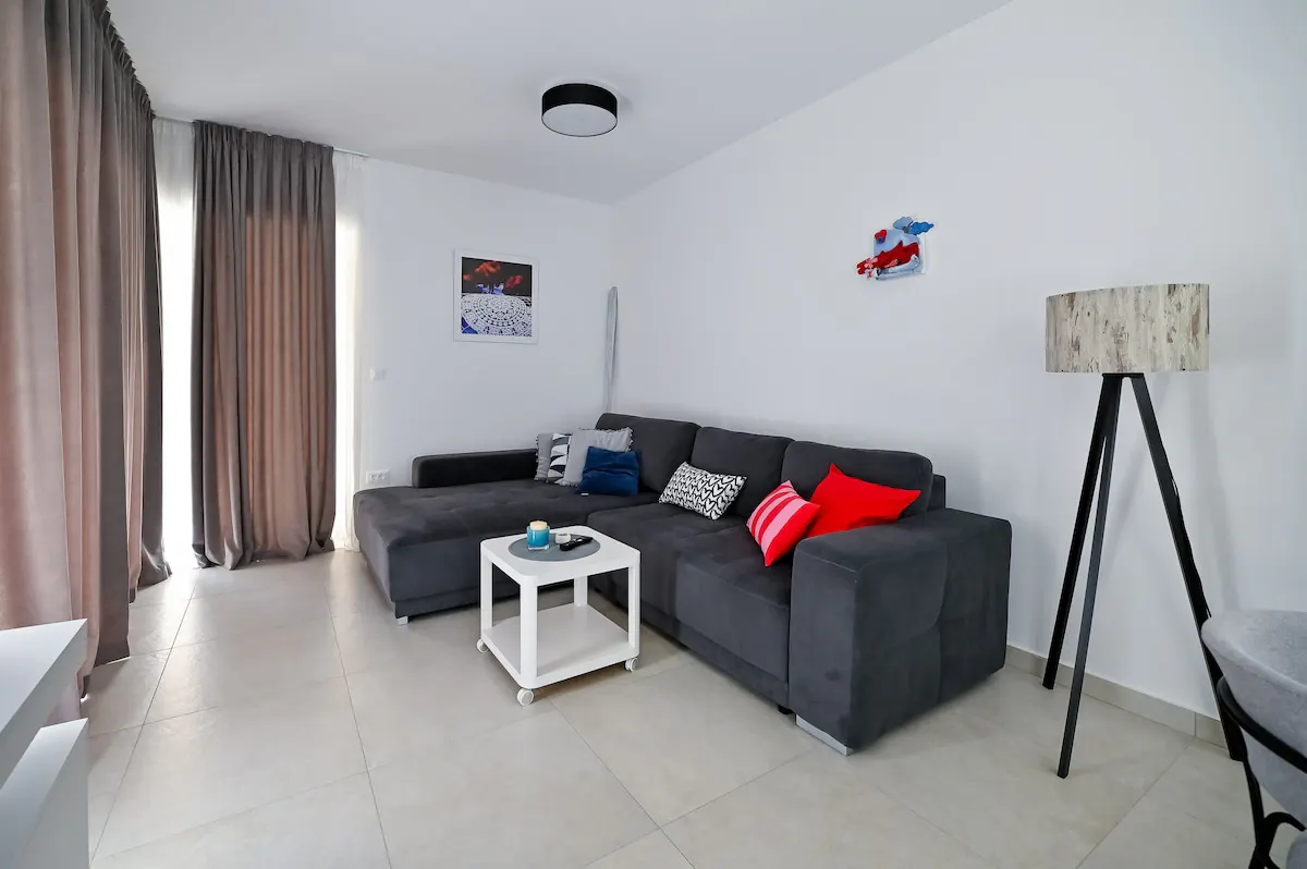 Living-room seating and tripod floor lamp at Apartment Festini in Pag