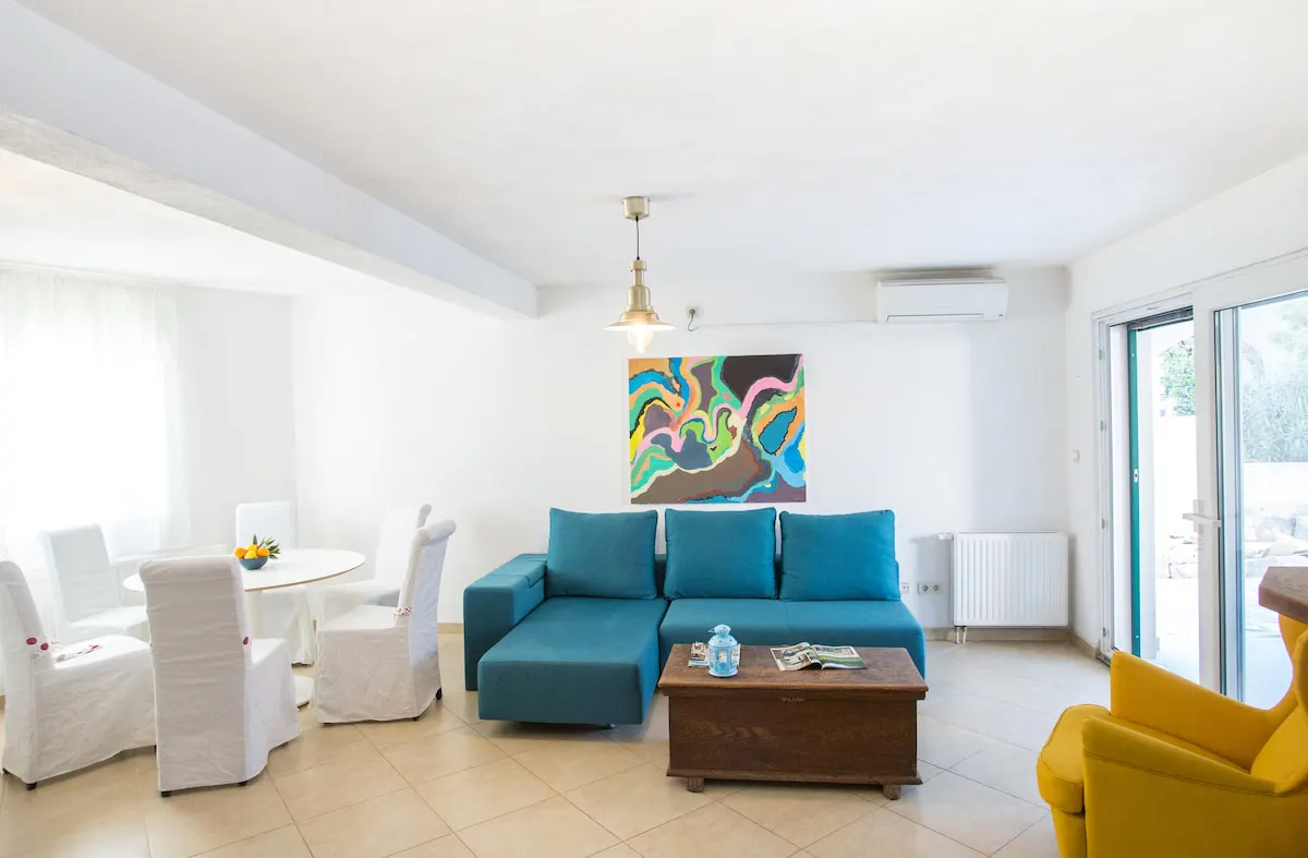 Blue sofa, yellow armchair and dining area at Villa Lapis Vis in Rukavac