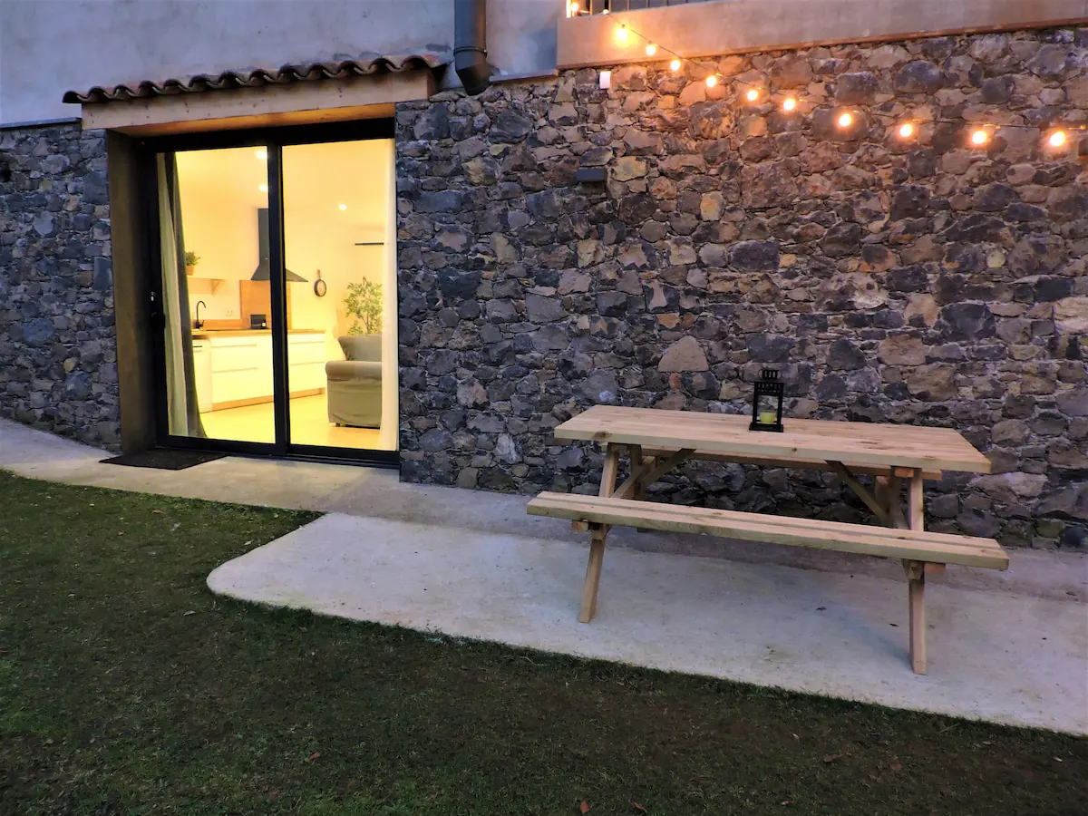 Steinmauer und Picknicktisch auf der Terrasse des Apartament de Mas Cal Teixidor in Santa Pau